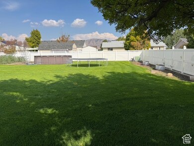 Fenced backyard featuring a trampoline and a mountain view