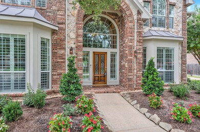 Stone and brick elevation and beautiful landscaping create an inviting entry.