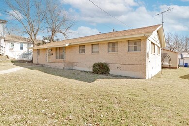 Side view of house with a lawn, brick siding, and 