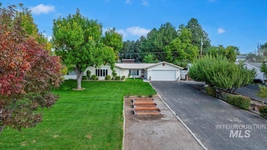 Single story home featuring a front yard, driveway, and an attached garage