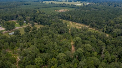 Aerial view of property and surrounding area featuring a heavily wooded area