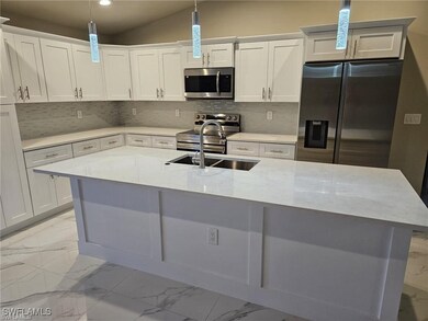 Kitchen featuring decorative light fixtures, sink,
