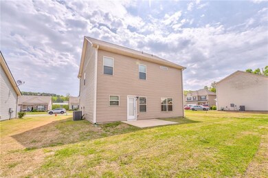 Rear view of property featuring a yard, a patio, a