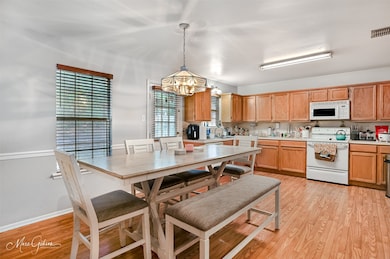 Dining area with light wood-style flooring and a chandelier