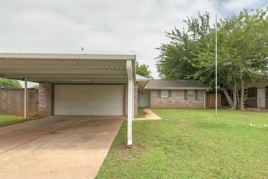 View of front of home with brick siding, a garage, and driveway