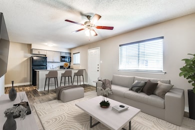 Living area featuring dark wood finished floors, a textured ceiling, and a ceiling fan