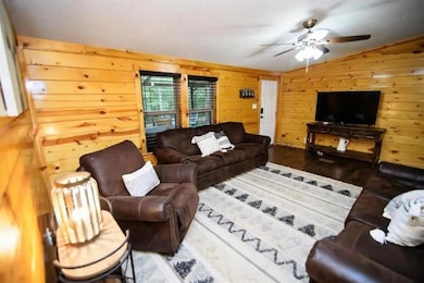 Living room featuring ceiling fan, lofted ceiling,