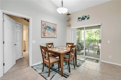 Dining area with light tile patterned floors and v