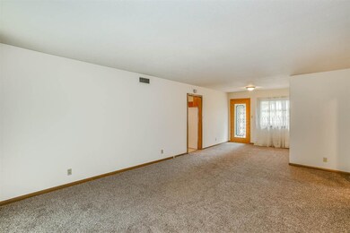 Living room has a space for a dining area.