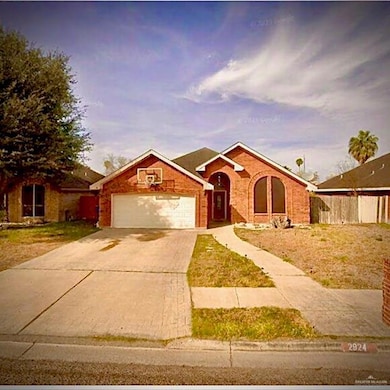 View of front facade featuring concrete driveway, an attached garage, and brick siding