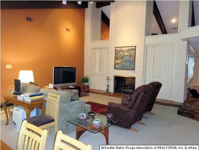Living room with fireplace open to dining room.