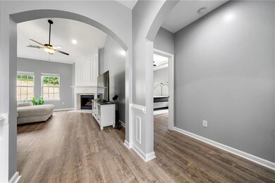 Living area with a ceiling fan, wood finished floors, baseboards, arched walkways, and recessed lighting