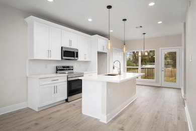 Kitchen and view to dining areas and outside deck.
