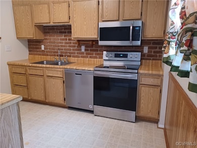 Kitchen featuring light floors, stainless steel ap