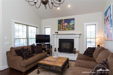 Living room features a gas log fireplace and views of the backyard.