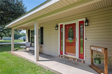 Doorway to property with a porch and a yard