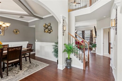 Entryway with wood finished floors, a chandelier, 