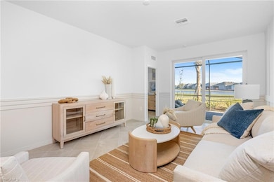 Living area featuring light tile patterned floors and a wainscoted wall