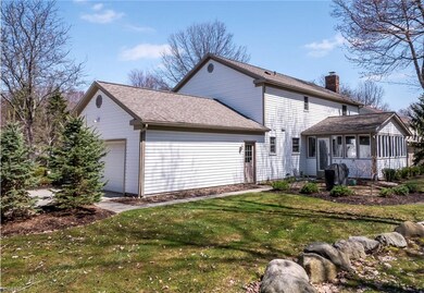 Rear view ov garage, man door, patio and sunroom.
