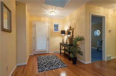Wide entry with gleaming hardwood floors.