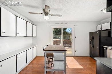 Kitchen with black fridge with ice dispenser, ligh