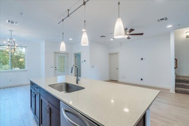 Kitchen with open floor plan, light stone counter