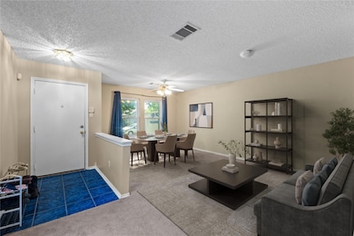 Living area with carpet floors, a ceiling fan, a 