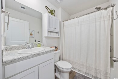Bathroom featuring vanity, toilet, wood finished floors, and shower / bath combo with shower curtain