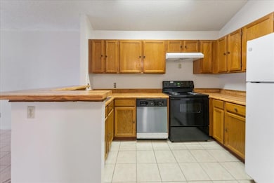 Kitchen featuring white refrigerator, stainless st