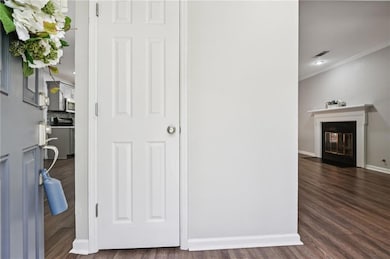 Corridor with dark wood-type flooring and ornamental molding