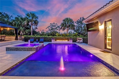 View of swimming pool with fence, a patio area, and a pool with connected hot tub