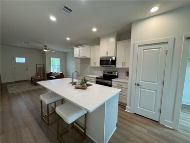 Kitchen with visible vents, a sink, dark wood fini