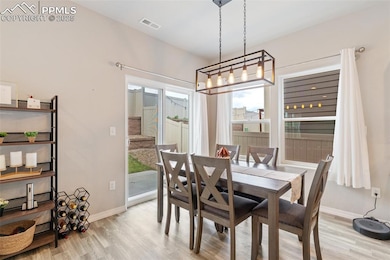 Dining space with light wood-type flooring and stairs