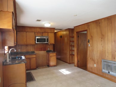 Kitchen featuring wood walls, sink, and heating un