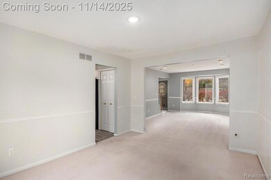 Empty room with light colored carpet and recessed lighting