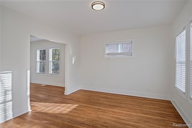 Empty room featuring light wood-style flooring and plenty of natural light
