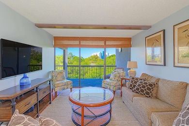 Living area with a textured ceiling, a wall of win