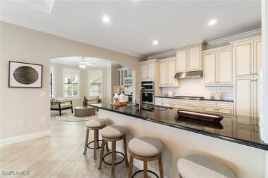 Kitchen featuring cream cabinetry, arched walkways