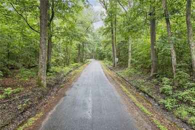 View of asphalt road featuring a wooded view