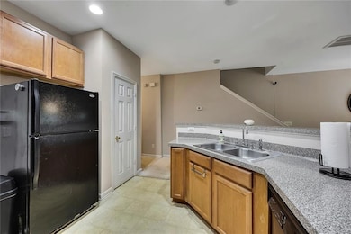 Kitchen with freestanding refrigerator, light countertops, dishwasher, and recessed lighting