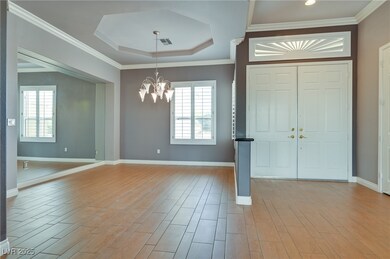 Entryway with a chandelier, a raised ceiling, base