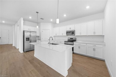 Kitchen featuring stainless steel appliances, a sink, light wood finished floors, white cabinets, and recessed lighting
