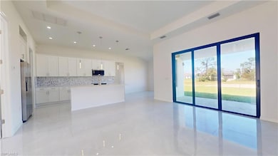 Kitchen featuring light countertops, backsplash, v