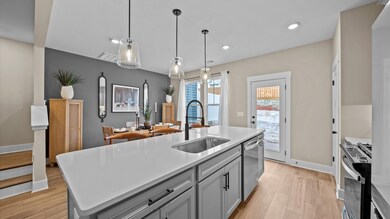 Kitchen with gray cabinetry and large island for counterstools