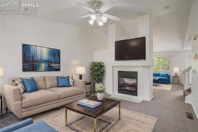 Virtually Staged Living room featuring a tile fireplace, carpet floors, ceiling fan, and high vaulted ceiling