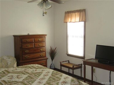 Mast3er bedroom with ceiling fan and newer carpet.