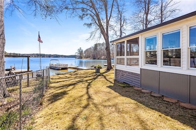 View of yard with fence, a water view, a sunroom, 