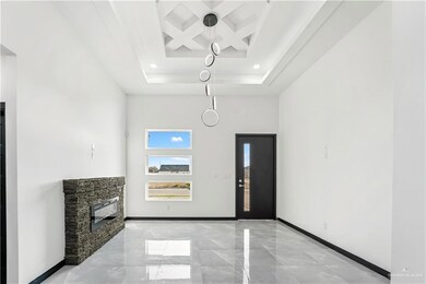 Foyer featuring beamed ceiling, coffered ceiling, a fireplace, and a towering ceiling