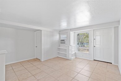 Empty room featuring light tile patterned floorin