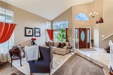 Foyer with high vaulted ceiling, a chandelier, car